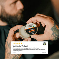 Das Bartwachs von der Brooklyn Soap Company mit Aloe Vera und Menthol in Barbershop-Qualität. Formt den Bart präzise und sorgt für ein gepflegtes, glänzendes Finish. Geöffnete Dose Bartwachs wird in der Hand gehalten, im Hintergrund ein bärtiger Mann; ergänzt durch eine Kundenbewertung.