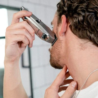 Mann rasiert sich die Haare mit einem Haarschneider