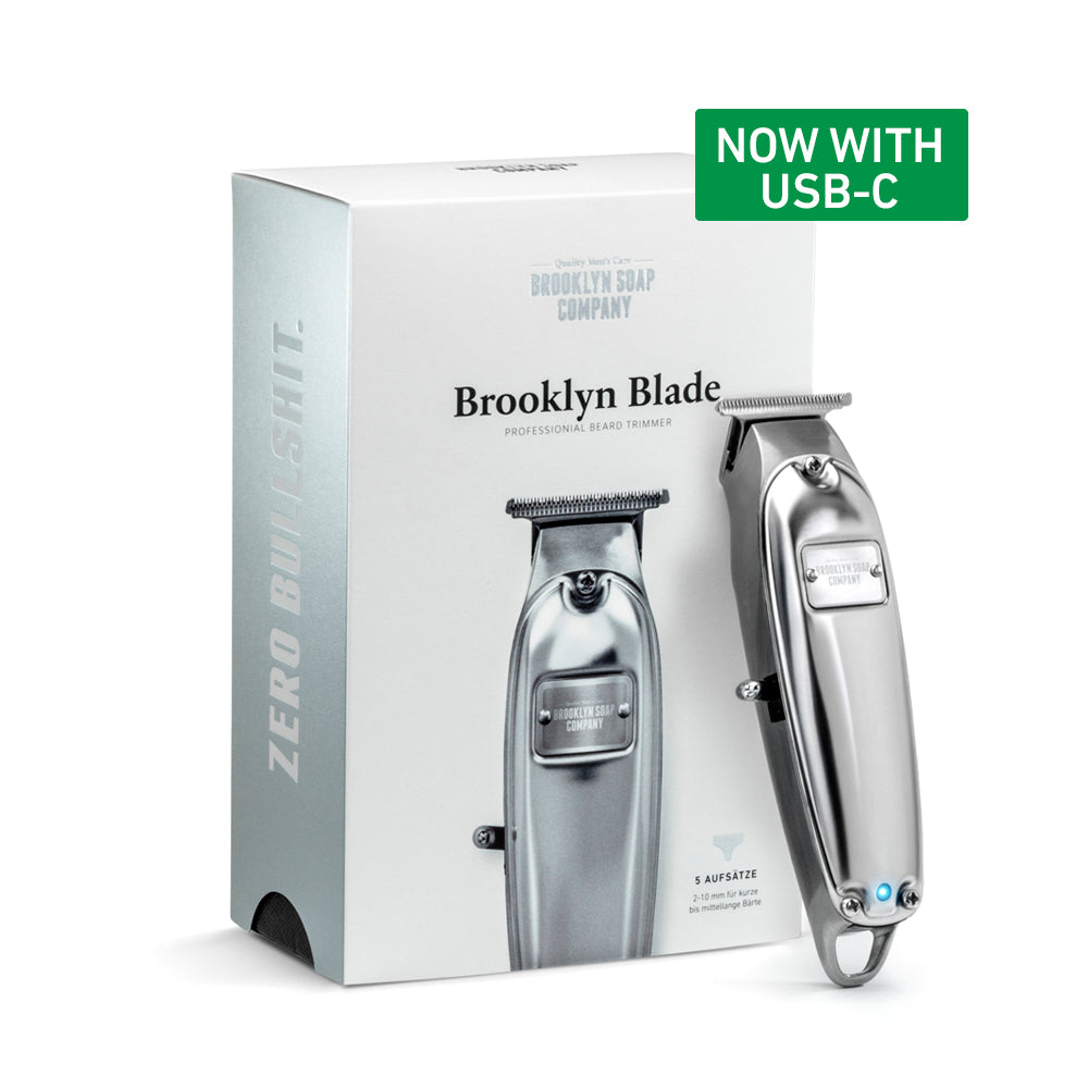 Brooklyn Blade beard trimmer in front of its product packaging, featuring a green label reading 'Now with USB-C [EU] [INT] [EN-featured]