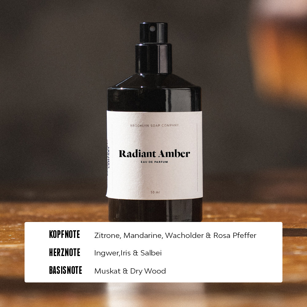 Radiant Amber Eau de Parfum von der Brooklyn Soap Company für Männer mit frischer Kopfnote aus Zitrone, Mandarine, Wacholder und rosa Pfeffer, würziger Herznote aus Ingwer, Iris und Salbei sowie einer warmen Basisnote aus Muskat und Dry Wood.
